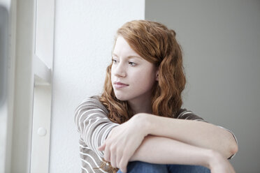 Germany, Munich, woman looking out of window - RBF001436