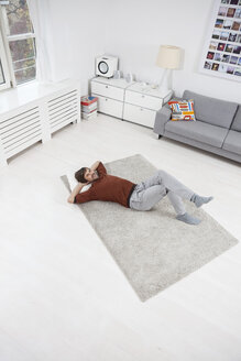 Germany, Munich, Man lying on floor, relaxing - RBF001454