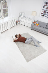 Germany, Munich, Man lying on floor, relaxing - RBF001456