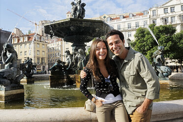 Portugal, Lisboa, Baixa, Rossio, Praca Dom Pedro IV, lächelndes junges Paar vor einem Springbrunnen - BIF000043