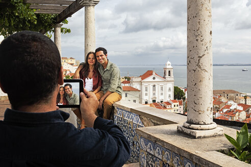 Portugal, Lisboa, Alfama, Miradouro de Santa Luzia, jemand fotografiert ein junges Paar - BIF000067