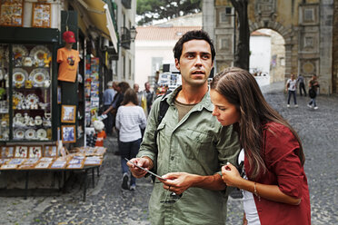 Portugal, Lisboa, Baixa, Rossio, young couple looking at postcard - BIF000022