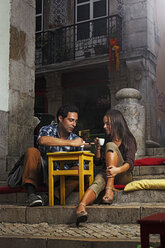 Portugal, Lisboa, Bairro Alto, junges Paar sitzt in der Abenddämmerung in einem Straßencafé - BIF000004