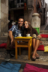 Portugal, Lisboa, Bairro Alto, junges Paar sitzt in der Abenddämmerung in einem Straßencafé - BIF000003