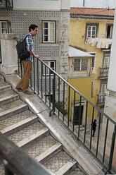 Portugal, Lisboa, Mouraria, junger Mann auf einer Treppe stehend - BIF000001