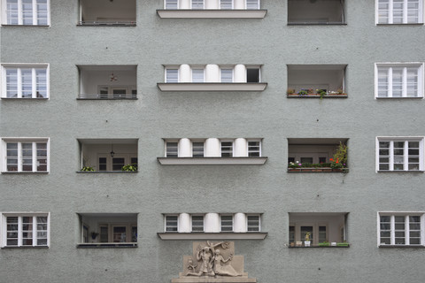 Deutschland, Bayern, München, Teil einer grauen Hausfassade mit Fenstern, Loggien und Skulpturen, lizenzfreies Stockfoto