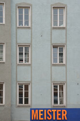 Deutschland, Bayern, München, Teil einer grauen Hausfassade mit Fenstern und Schild - AX000576