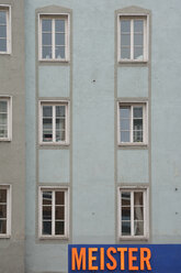 Germany, Bavaria, Munich, part of grey house front with windows and sign - AX000576