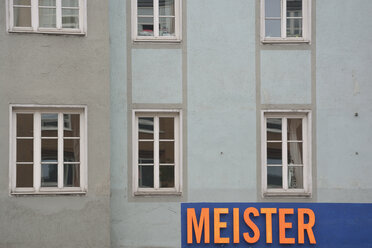 Deutschland, Bayern, München, Teil einer grauen Hausfassade mit Fenstern und Schild - AX000575