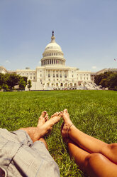 USA, Washington D.C., Pärchen entspannt sich auf einer Wiese vor dem Kapitol - MBEF000902