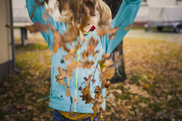 Little boy throwing autumn leaves - MJF000417