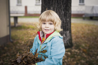 Portrait of little boy holding autumn leaves - MJF000416