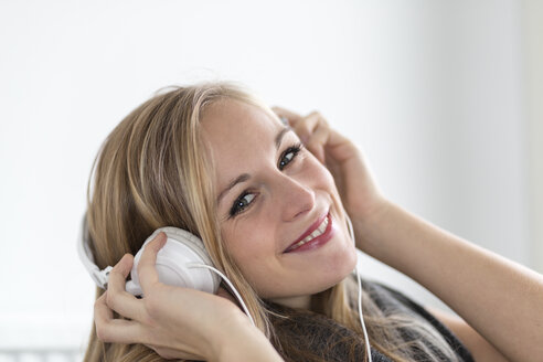 Porträt einer lächelnden jungen Frau mit Kopfhörern, Nahaufnahme - DRF000304