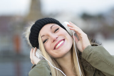 Portrait of smiling young woman with headphones, close-up - DRF000297