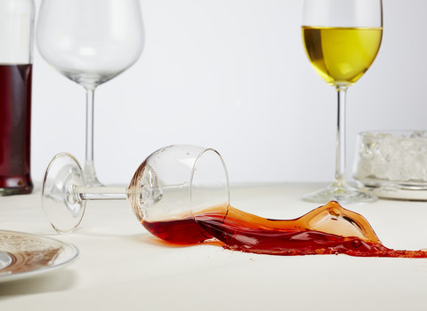 Ein Glas Rotwein kippt auf den Tisch, lizenzfreies Stockfoto