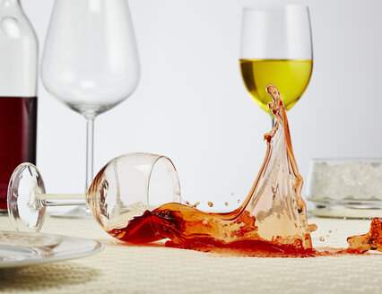 Ein Glas Rotwein kippt auf den Tisch - AKF000272