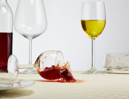 Ein Glas Rotwein kippt auf den Tisch - AKF000273