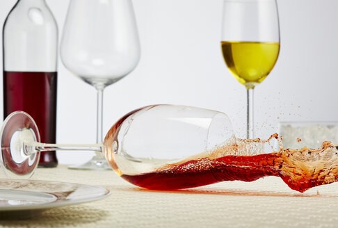 Ein Glas Rotwein kippt auf den Tisch - AKF000274