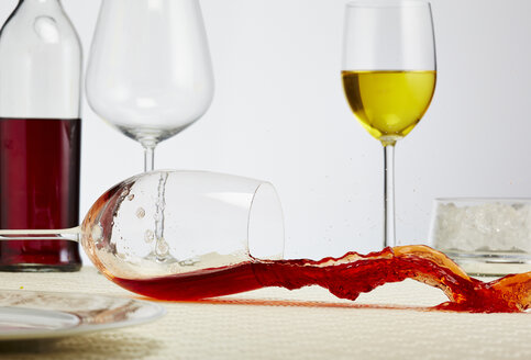 Ein Glas Rotwein kippt auf den Tisch - AKF000275