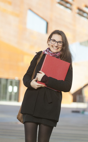 Lächelnder Student mit Ordner im Freien, Porträt, lizenzfreies Stockfoto