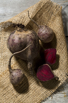 Geschnittene und ganze Rote Bete (Beta vulgaris) auf Jute - MAEF007437