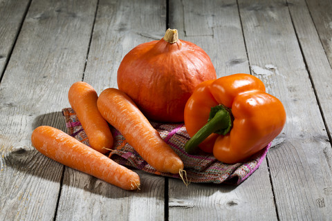 Hokkaido-Kürbis, Karotten und Paprika auf Holztisch, lizenzfreies Stockfoto