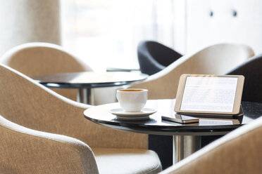 Digitales Tablet, Smartphone und Tasse Kaffee auf dem Tisch in der Hotellobby - MLF000236