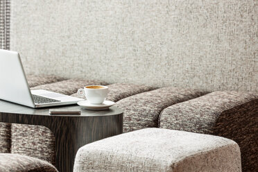 Poland, Warsaw, laptop, smartphone and coffee cup at lounge of hotel - MLF000239