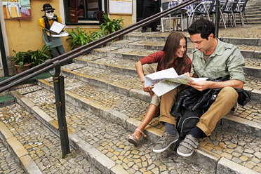 Portugal, Lisboa, Carmo, Calcada du Duque, junges Paar mit Stadtplan auf einer Treppe sitzend - BIF000077