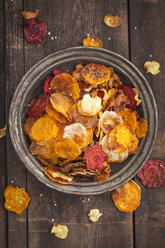Roasted vegetable chips made of parsnips, sweet potatoes, beetroots, carrots and turnips on plate - ECF000397