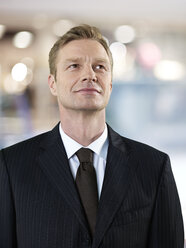 Portrait of smiling businessman looking up - STKF000700