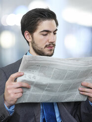 Portrait of businessman reading newspaper - STKF000708