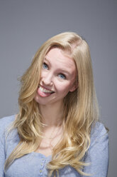 Portrait of young woman with outstretched tongue - MAEF007545