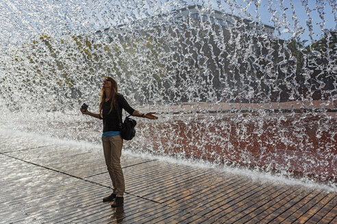Portugal, Lissabon, Olivais, Parque das Nacoes, Oceanario de Lisboa, Frau vor einem Wasserfall stehend - BIF000143
