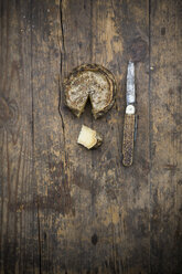 Tomme de Savoie cheese and knife on wooden table - LVF000351