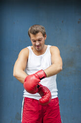 Boxer with red boxing gloves preparing for a fight - PAF000074