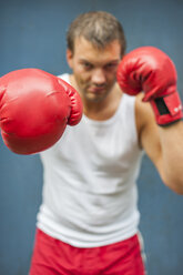 Boxer with red boxing gloves fighting - PAF000085