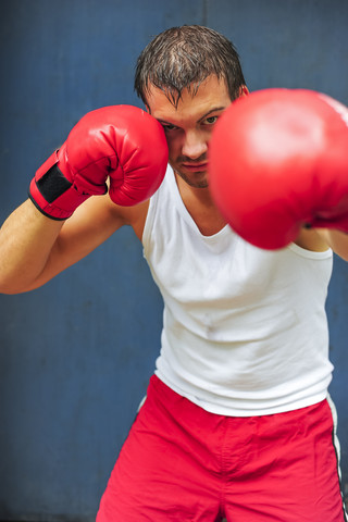 Boxer mit roten Boxhandschuhen im Kampf, lizenzfreies Stockfoto