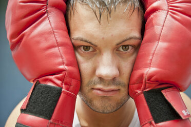 Boxer with red boxing gloves, portrait - PAF000070