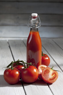 Hausgemachter Tomatensaft auf Holztisch - CSF020482