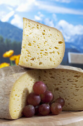 Bethmale-Käse mit Trauben vor Bergkulisse, digitales Komposit - CSF020442