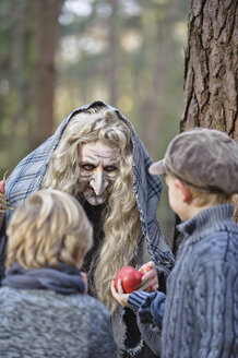 Deutschland, Nordrhein-Westfalen, Mönchengladbach, Szene aus dem Märchen Hänsel und Gretel, Hexe bietet den Kindern einen Apfel an - CLPF000026