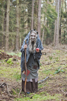 Germany, North Rhine-Westphalia, Moenchengladbach, Scene from fairy tale, witch holding an apple in the woods - CLPF000029