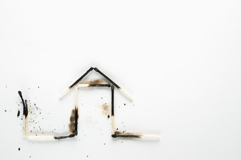 Burnt down matches shaped like a house stock photo