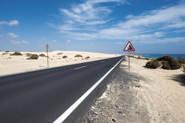 Spain, Fuerteventura, Corralejo, Parque Natural de Corralejo, view of empty road and road sign - VI000095