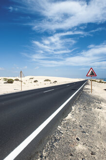 Spanien, Fuerteventura, Corralejo, Parque Natural de Corralejo, Blick auf leere Straße und Straßenschild - VI000166