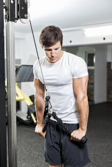 Österreich, Klagenfurt, Mann im Fitness-Center beim Kabel-Training - DAWF000063