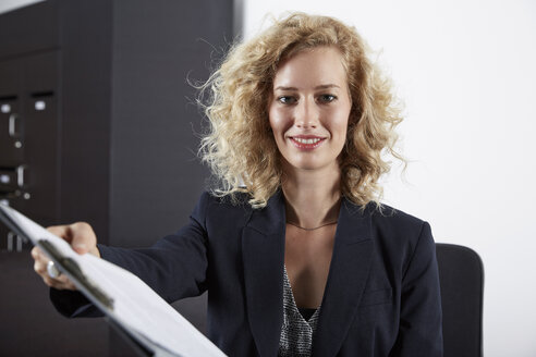 Germany, Neuss, Receptionist holding clip board - STKF000791