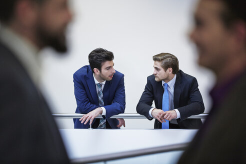 Germany, Neuss, Businessmen talking in corridor - STKF000801