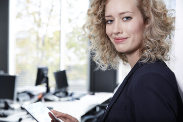 Germany, Neuss, Young business woman using digital tablet - STKF000815